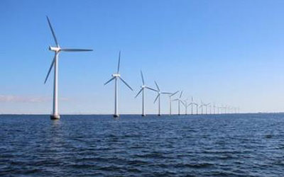 平靜的海面上佇立著一排風(fēng)力發(fā)電機，體現(xiàn)永磁材料在風(fēng)力發(fā)電領(lǐng)域的應(yīng)用